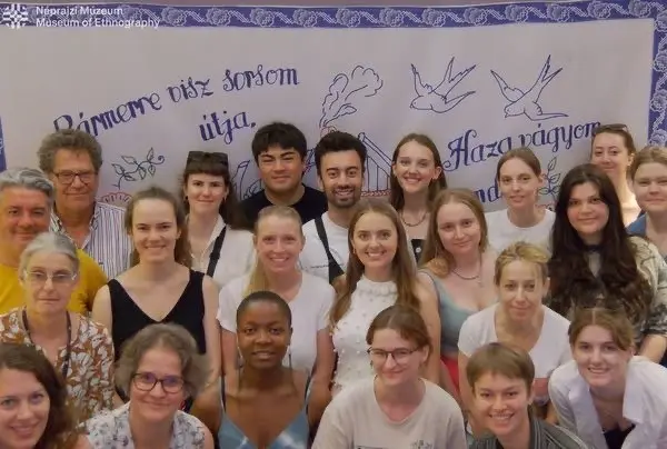 Studierende in Budapest vor einem mit ungarischen Wörtern bestickten Tuch.