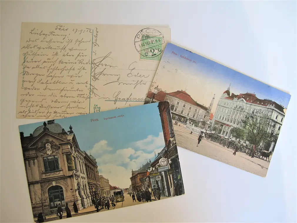 Das Bild zeigt 3 Postkarten: 2 Ansichten von Pécs mit Straßenszene und Häusern sowie die Rückseite einer Ansichtskarte mit handschriftlichem Text.