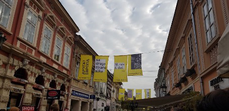 Das Bild zeigt Plakate zwischen Häusern anlässlich der Kulturhauptstadt 2022 in Novi Sad